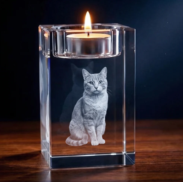 Portavelas de cristal con una mascota grabada en tres dimensiones, con una vela encendida arriba